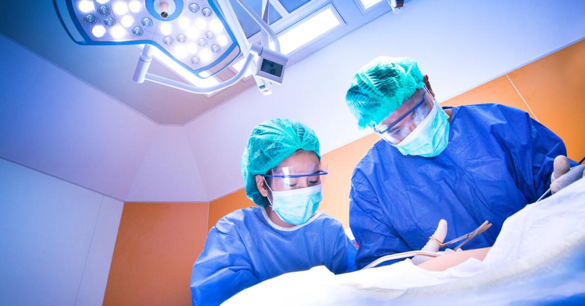 Operatiekamer met chirurg en operatieassistent bezig met ingreep