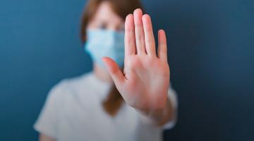 Verpleegkundige met haar hand omhoog om te zeggen: stop!
