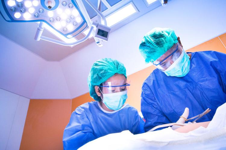 Operatiekamer met chirurg en operatieassistent bezig met ingreep